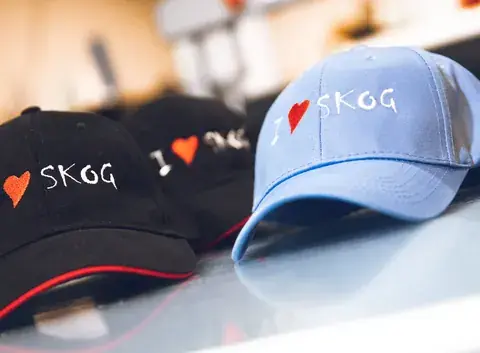Caps med «I love skog»-trykk i svart og lyseblått.