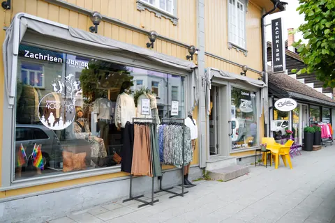 Butikkfasade i Kongsberg sentrum med skilt og vindusdekor.